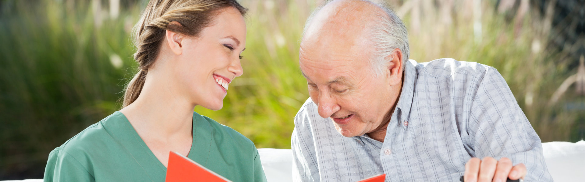 nurse and elderly man looking at the book