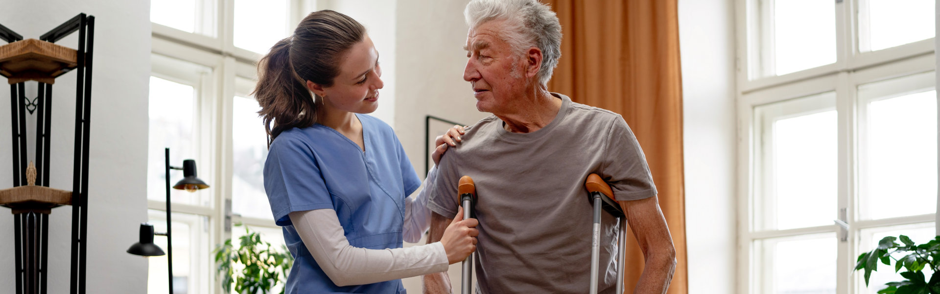 nurse assisting elderly man to walk